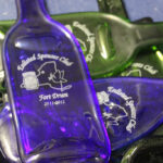 Laser etched flattened wine bottles